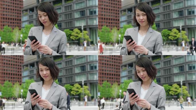 日本女商人在旅途中使用智能手机