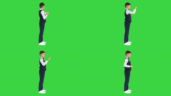 领结中的男生在绿色屏幕上触摸虚拟屏幕，色键