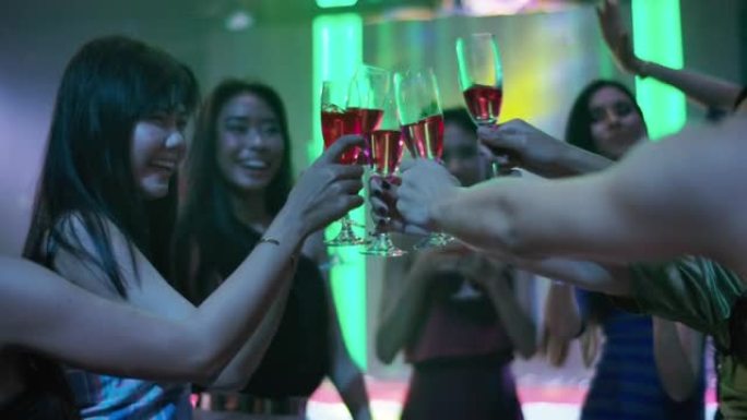 一群年轻的亚洲女性在夜总会跳舞和喝酒。