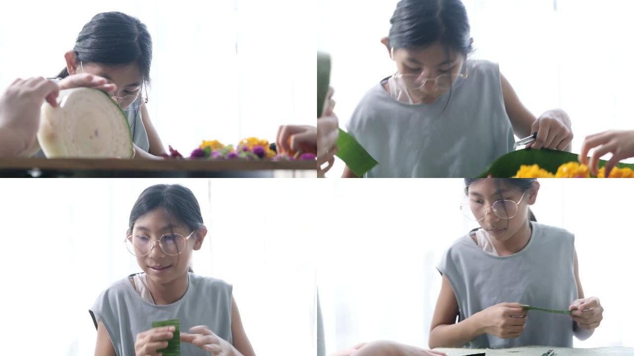 快乐的亚洲女孩为kathong插花 (用香蕉叶和花朵制成，漂浮在河中祈祷和感谢) 一起在家，为夜晚做