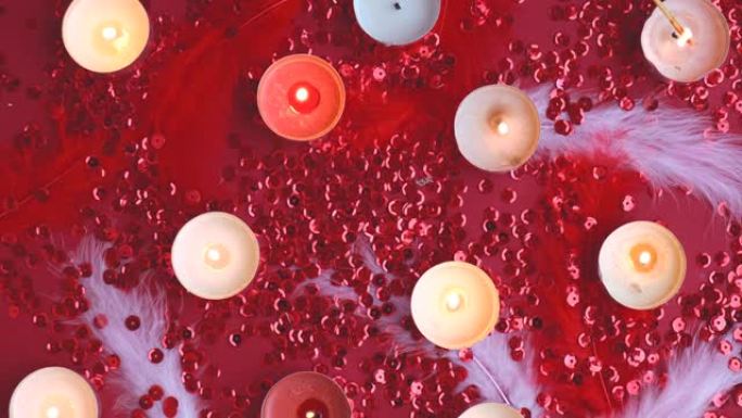 红色背景上燃烧的茶灯蜡烛的俯视图。浪漫的气氛与香薰茶轻蜡烛。情人节背景