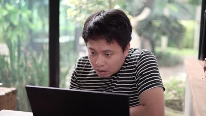 亚洲人在咖啡馆用笔记本电脑搜索。