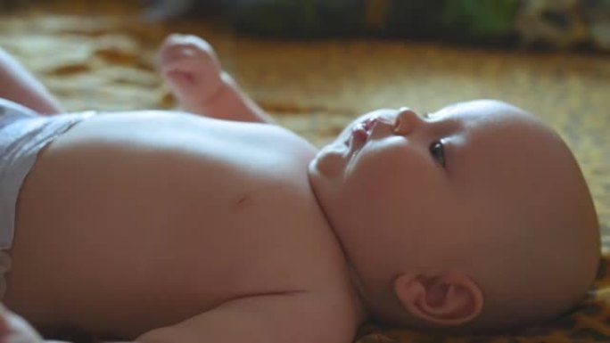 一个胖乎乎的四个月微笑的婴儿躺在床上。特写镜头。