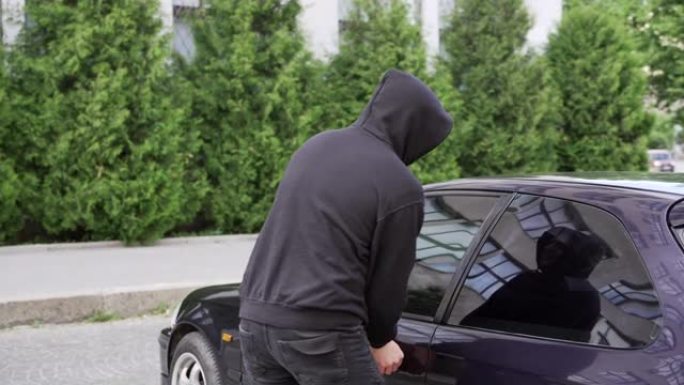 偷车贼偷车破门犯罪工作窃贼劫持偷车贼黑色巴拉克拉瓦帽衫试图闯入汽车螺丝刀