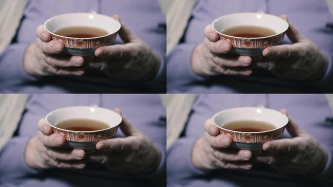 茶。一位老祖母正在用茶碟喝茶。