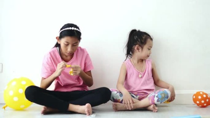 亚洲女孩在家一起在地板上抽气球，为家居装修概念做准备。