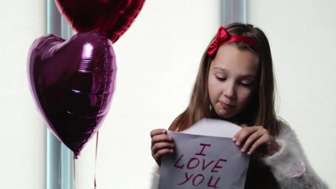 女孩在情人节打开了一个信封，上面写着 “我爱你”。
