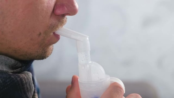 使用雾化器和吸入器进行治疗。病人通过吸入器喷嘴吸入喉咙。特写嘴唇和鼻子侧视图。