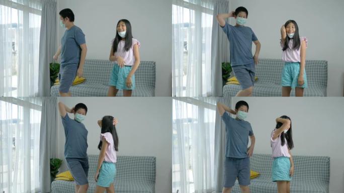 快乐的亚洲青春期男孩和他的妹妹戴着面具一起在家练习舞蹈，生活方式理念。