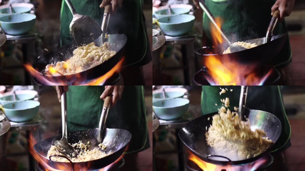 泰国曼谷约瓦拉吉路街头美食厨师在黑锅里用火做饭