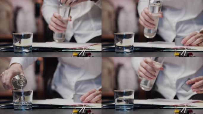 女商人的手在桌子上拿一杯水