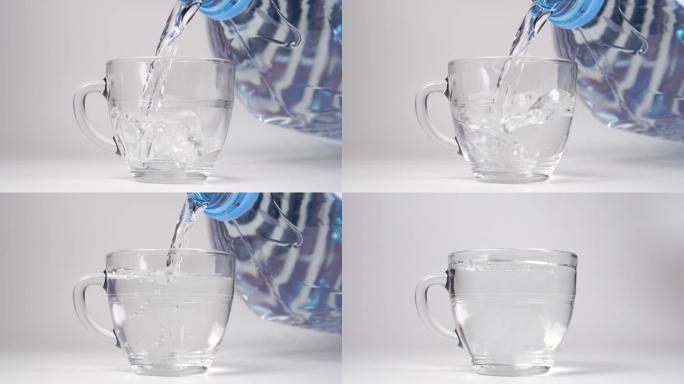 慢动作从一个大的五升塑料瓶将水倒入玻璃杯中
