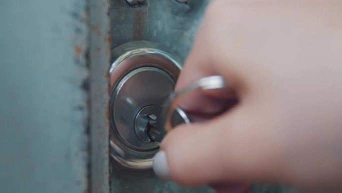 女孩用一把大钥匙打开门锁，走进门