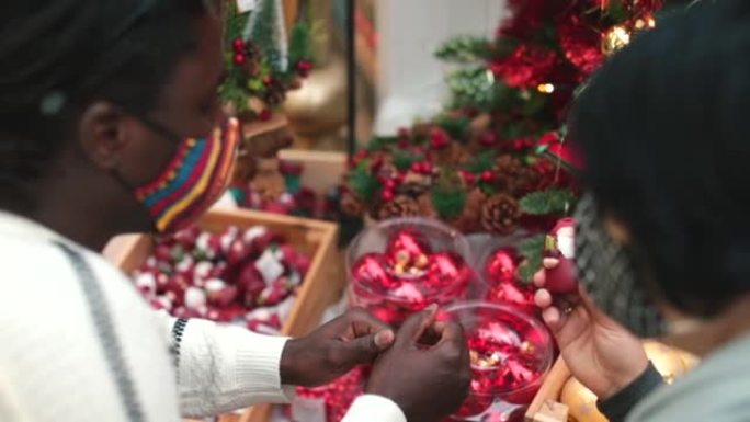 不同种族的蒙面夫妇讨论传统。圣诞老人雕像，圣诞节。