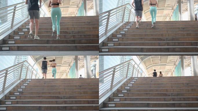 一对亚洲运动男女在大城市慢跑并通过楼梯