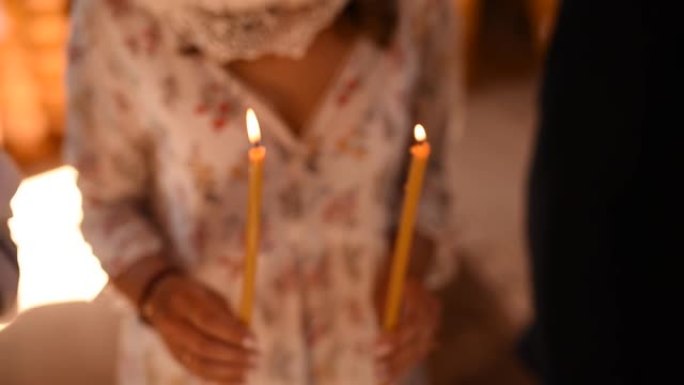 女人的手在教堂里拿着点燃的蜡烛