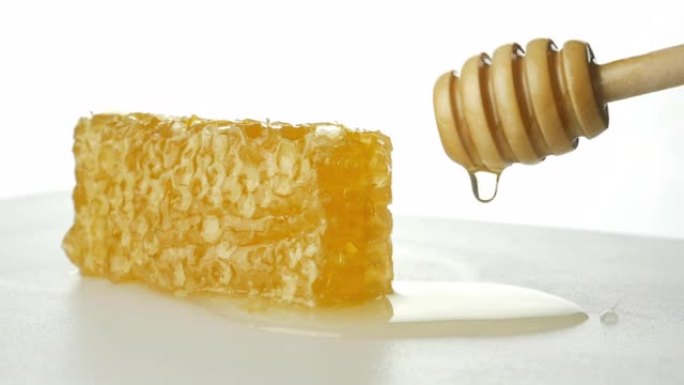 白色背景上有蜂蜜北斗七星的蜂窝，蜂蜜北斗七星浸泡在蜂蜜中慢慢落下的蜂蜜滴视频