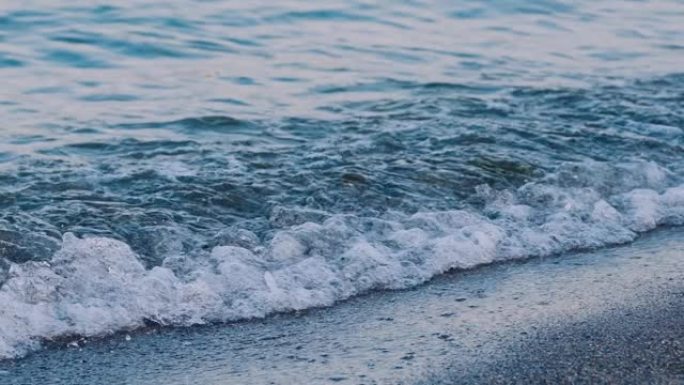 海边的海浪。令人惊叹的海水景色。海浪在卵石滩上撞击，形成白色泡沫。慢动作。