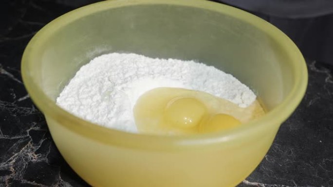 向日葵油倒入装有面粉和鸡蛋的碗中