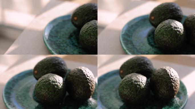 美味的哈斯鳄梨在绿色陶瓷盘上准备午餐。健康饮食的天然成分