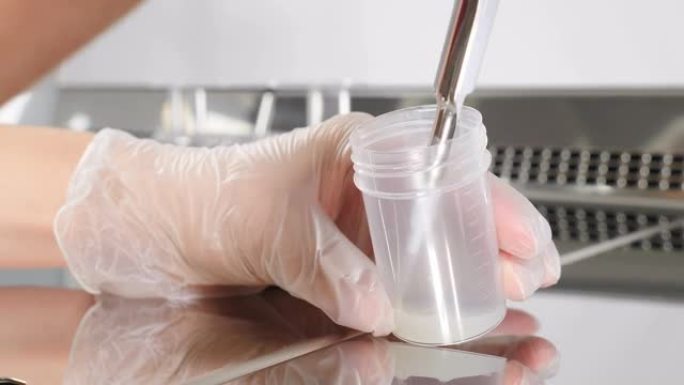 现代微生物学柜的实验室工作人员。医生处理精液样本的特写。科学家胚胎学家将精子从测试库中分发进行分析。