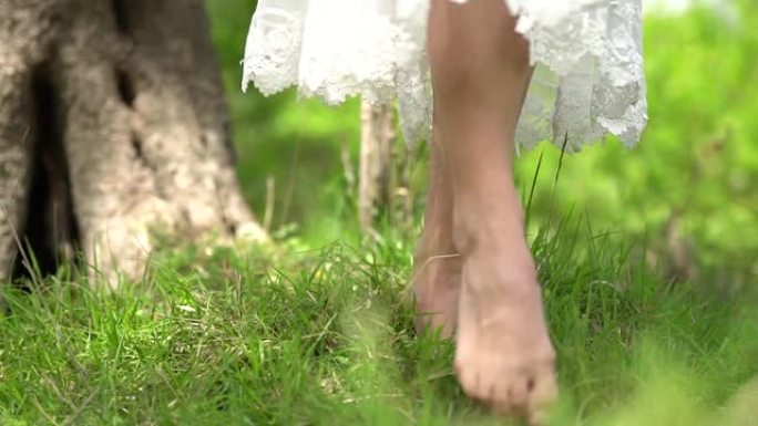 赤脚新娘在草地上行走，裙子在风中飘扬