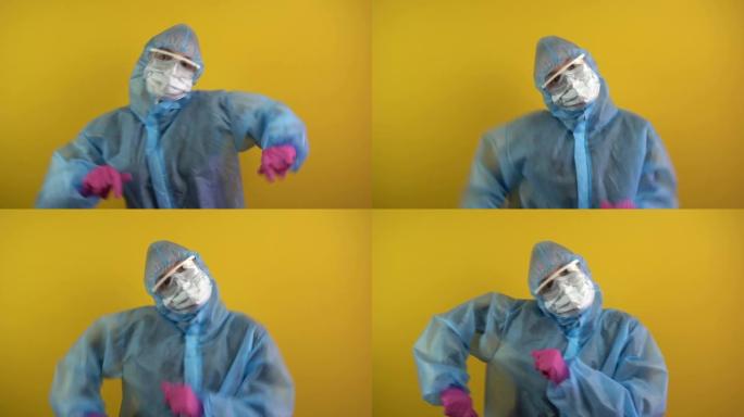 开朗、快乐的高加索医务工作者。医生穿着黄色背景的防护服跳舞。战胜新型冠状病毒肺炎后的幸福。