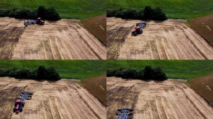 带有耙的红色拖拉机为种植农作物做准备。无人机空中透视图。