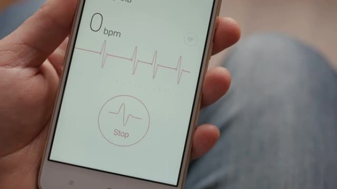 男人正在看智能手机上的健康监控应用程序。用智能手机上的健康应用程序监控心脏脉搏。