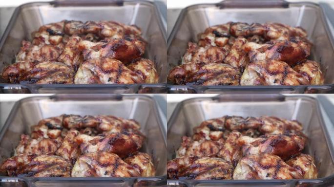 在美国午餐或晚餐时，在户外用甜烧烤酱窒息的美味烤鸡的手持照片
