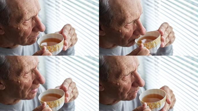 一位老人喝茶，看着窗外