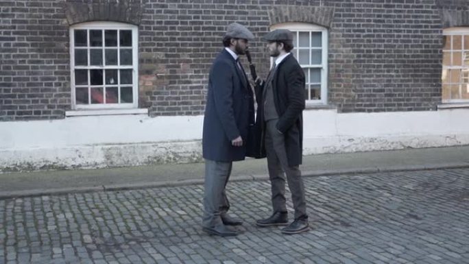 两名男子在鹅卵石街道上相遇，穿着花呢西装和平顶帽，吵架