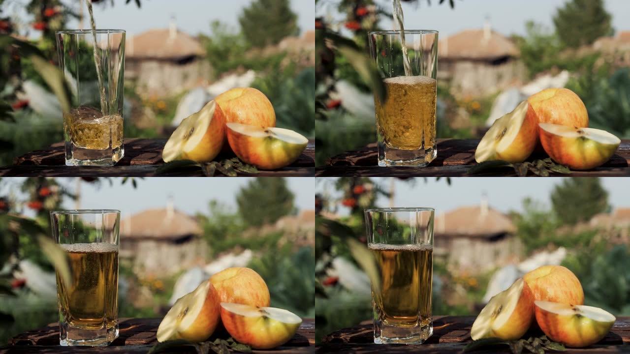 苹果汁倒入玻璃杯中。在乡间别墅和大自然的背景下，将红苹果汁倒入透明玻璃中，附近有新鲜苹果。特写