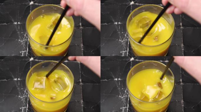 酒杯配橙黄色果汁和冰块。