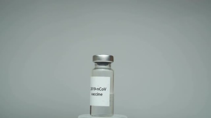 一瓶抗SARS疫苗-CoV-2病毒。特写安瓿与新型冠状病毒肺炎冠状病毒疫苗。安瓿旋转。击败冠状病毒的