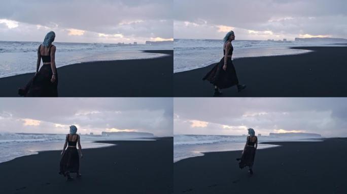 蓝色头发酷女孩沿着黑海滩散步