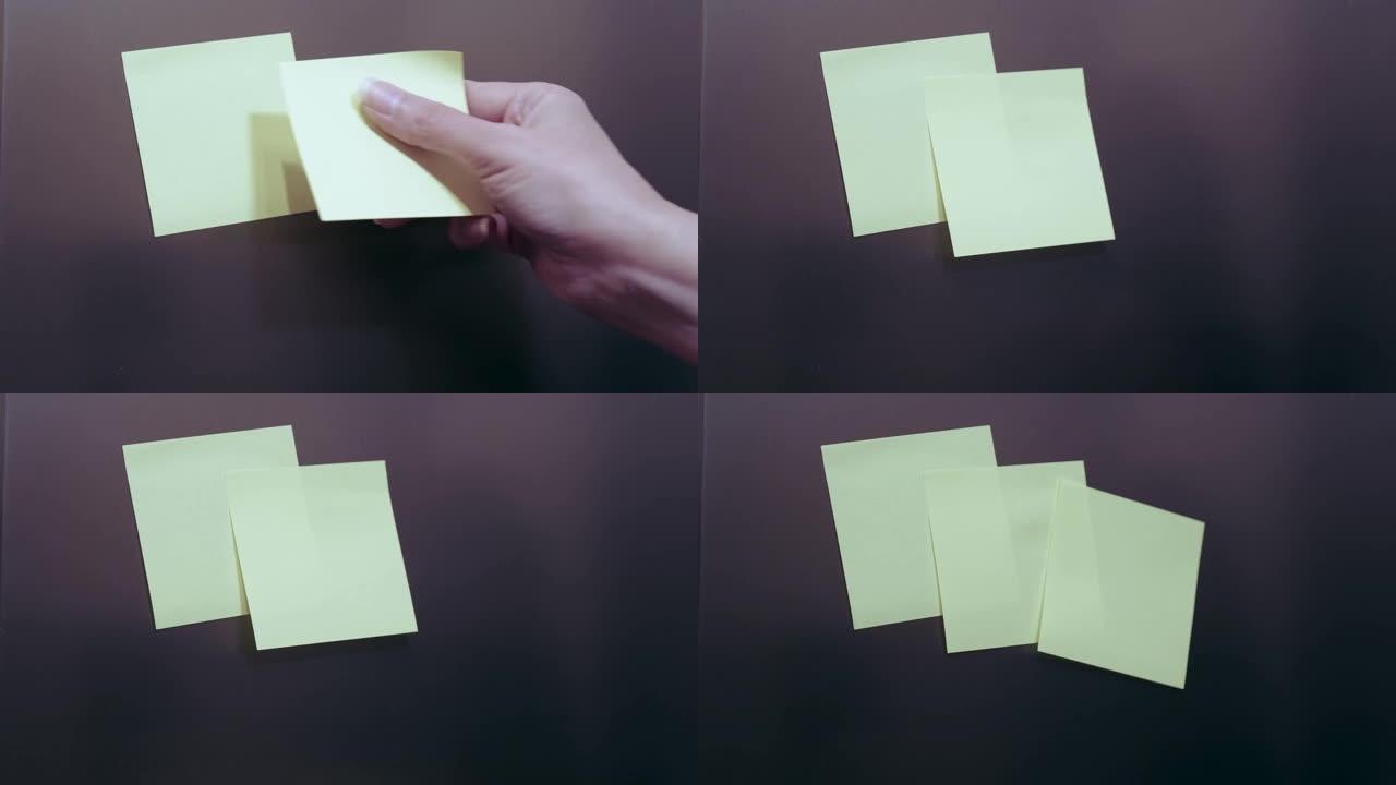 女人的手在冰箱上贴黄色粘性贴纸。用复制空间模拟。