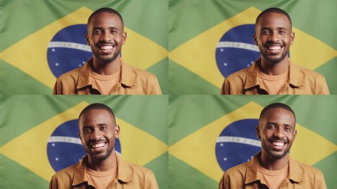 欢乐的黑人男子对着巴西国旗对着镜头微笑