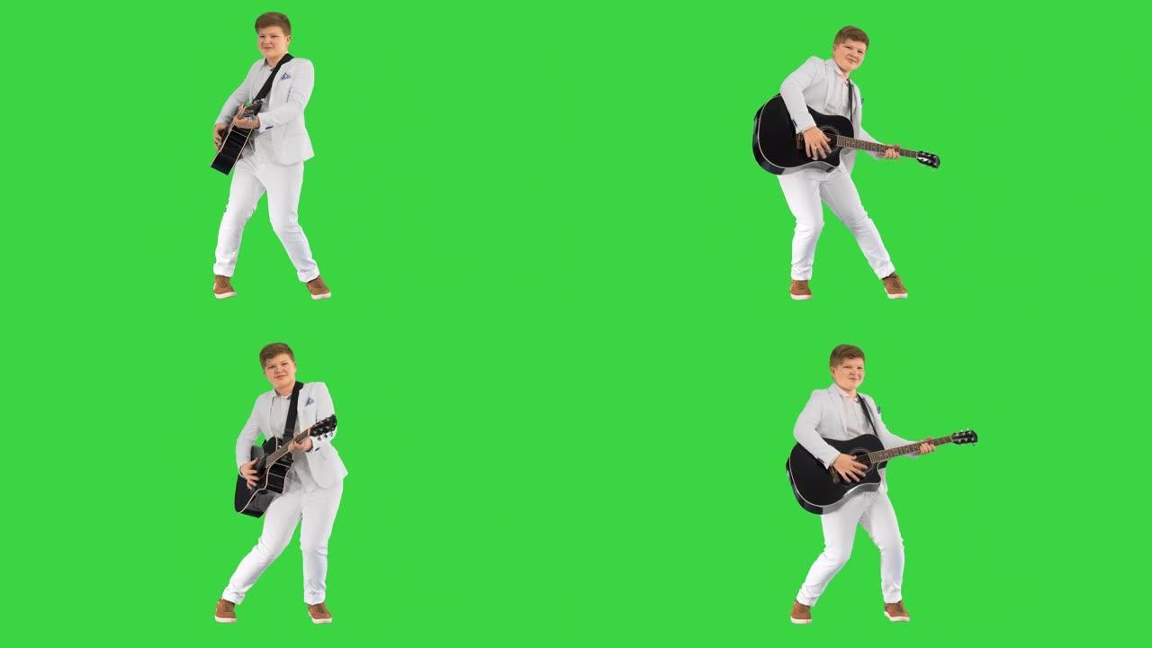 男孩像猫王一样在绿色屏幕上拿着吉他，色键