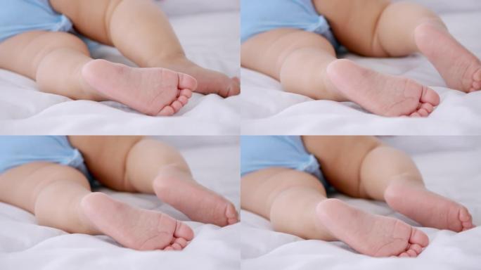 初生婴儿的脚躺在家里的床上。