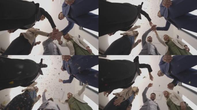 一群兴奋的商人在办公室里用五彩纸屑庆祝和敬酒