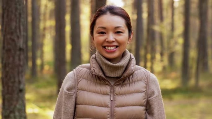 快乐微笑的亚洲年轻女子在森林