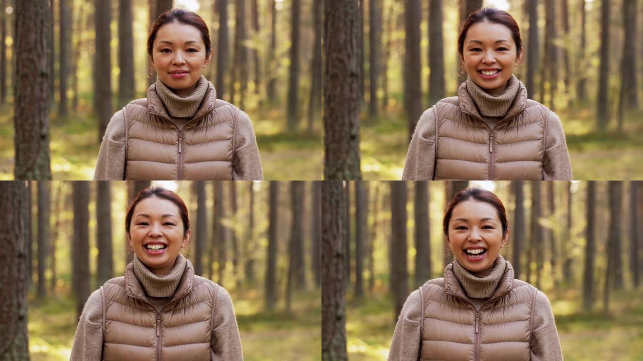 快乐微笑的亚洲年轻女子在森林