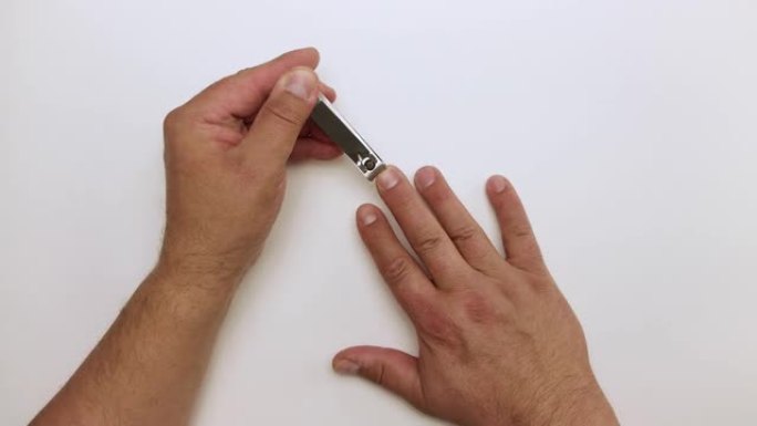 男性的手用钳子在中指上剪指甲。