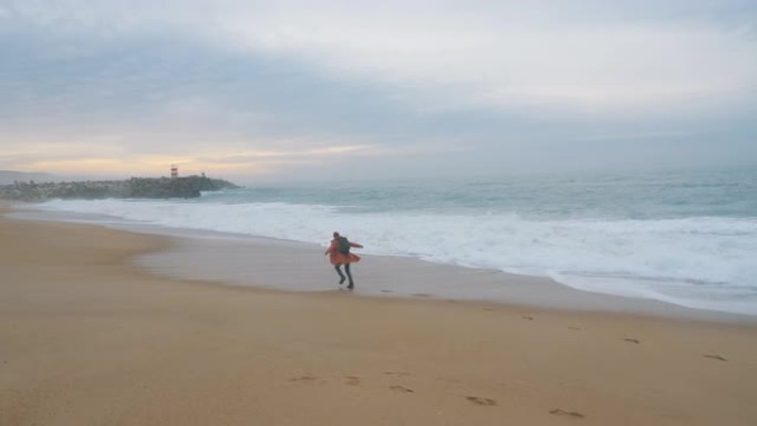 积极的家伙从海滩上滚滚的泡沫海浪中奔跑