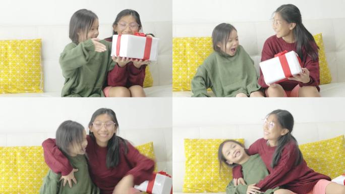 亚洲女孩在家给妹妹送礼盒，庆祝节日。