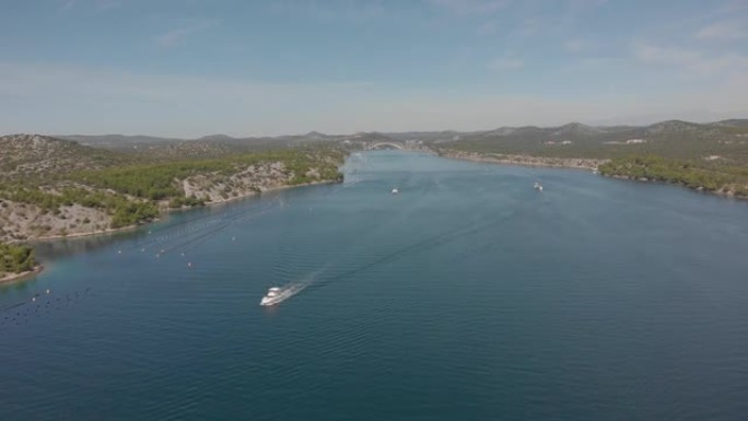 丘陵海岸之间的通道。摩托艇漂浮在蓝色海水上。空中射击