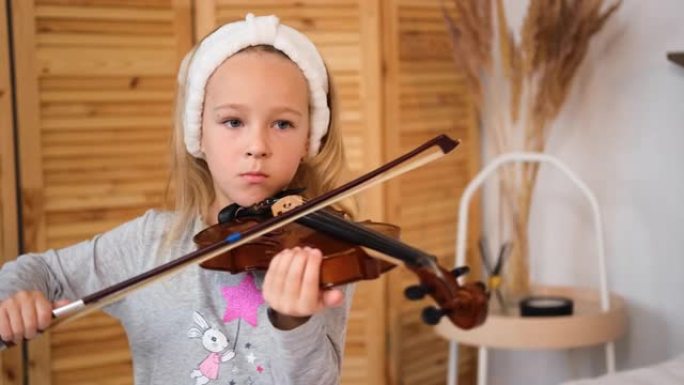 集中的小女孩在家拉小提琴