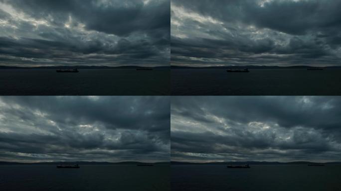 到比赛中，海上笼罩着可怕的乌云。海里有船只。