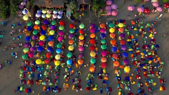 游客在著名的巴厘岛著名的旅游胜地塞米尼亚克海滩享受五颜六色的雨伞。2020年1月15日: 印度尼西亚